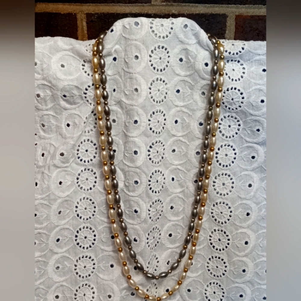 Vintage double strand faux pearls with gold toned accents. 24 inches long.